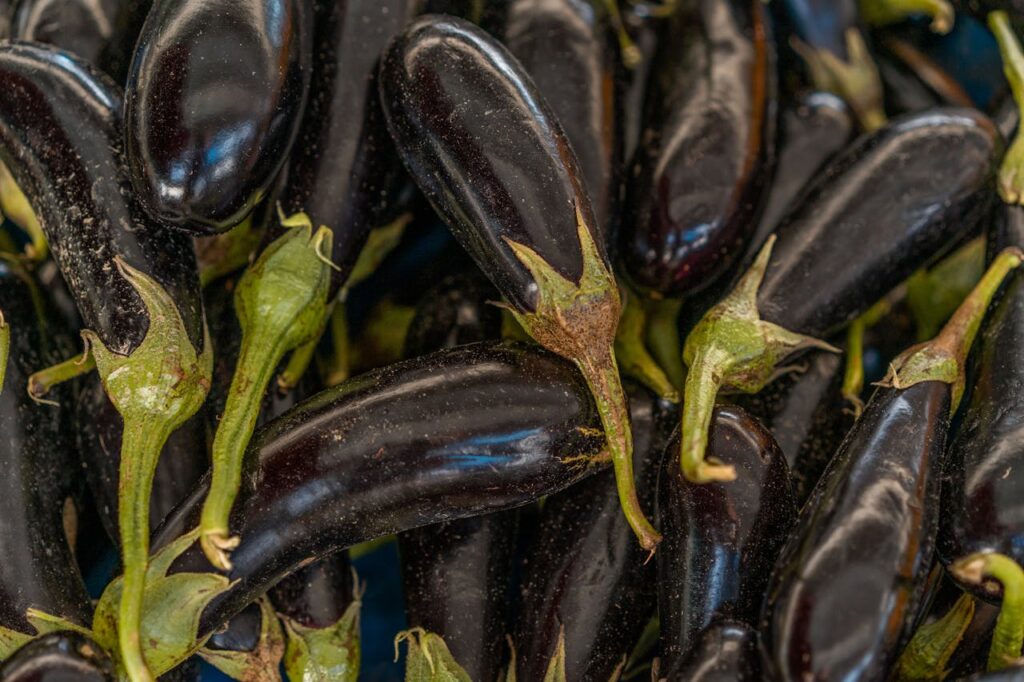 A detailed close-up of fresh, vibrant purple eggplants, showcasing their organic texture.